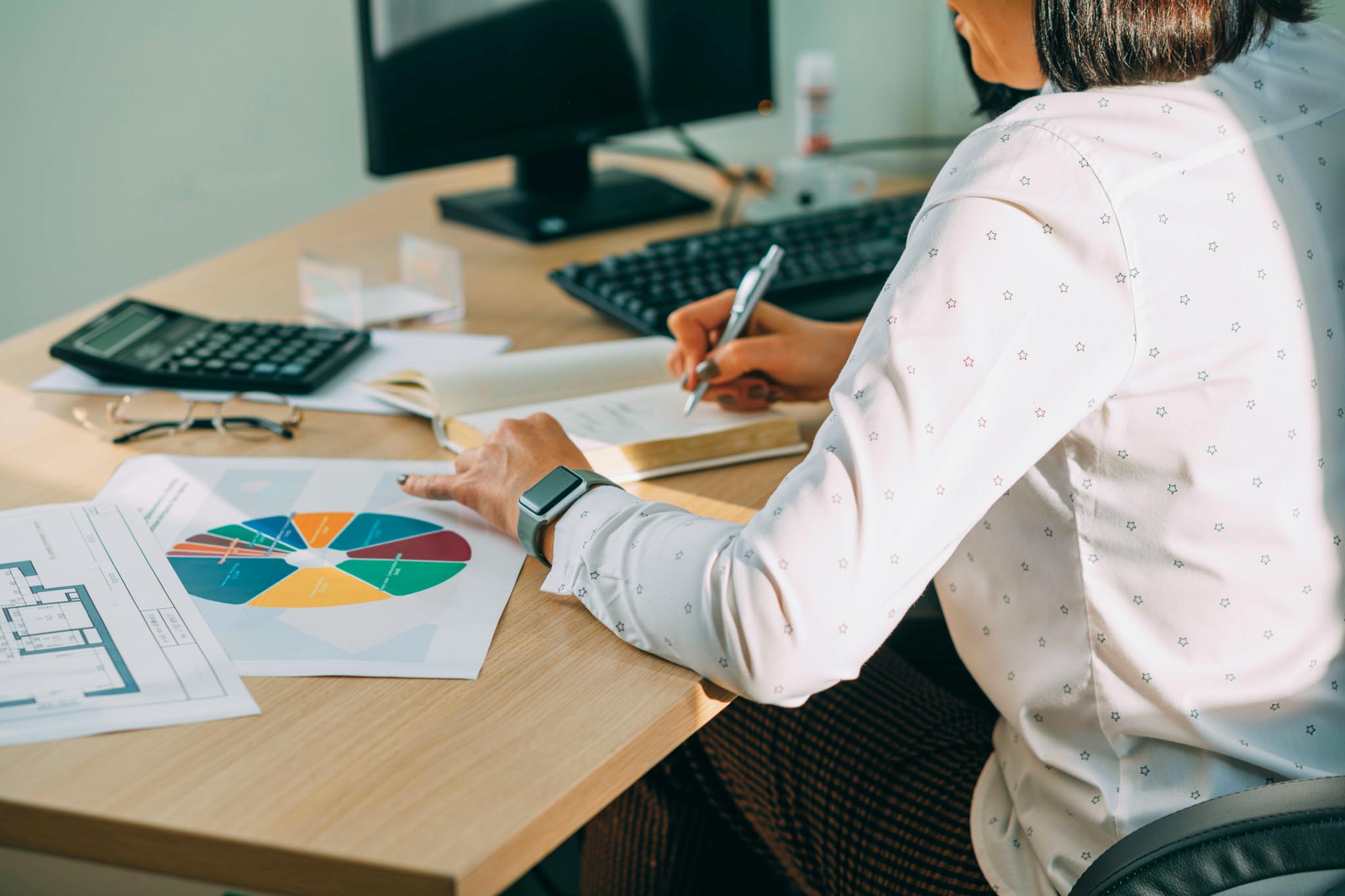 Calculating Success: Hands-on Strategies for Office Productivity Amidst Diagrams, woman is planning a profit